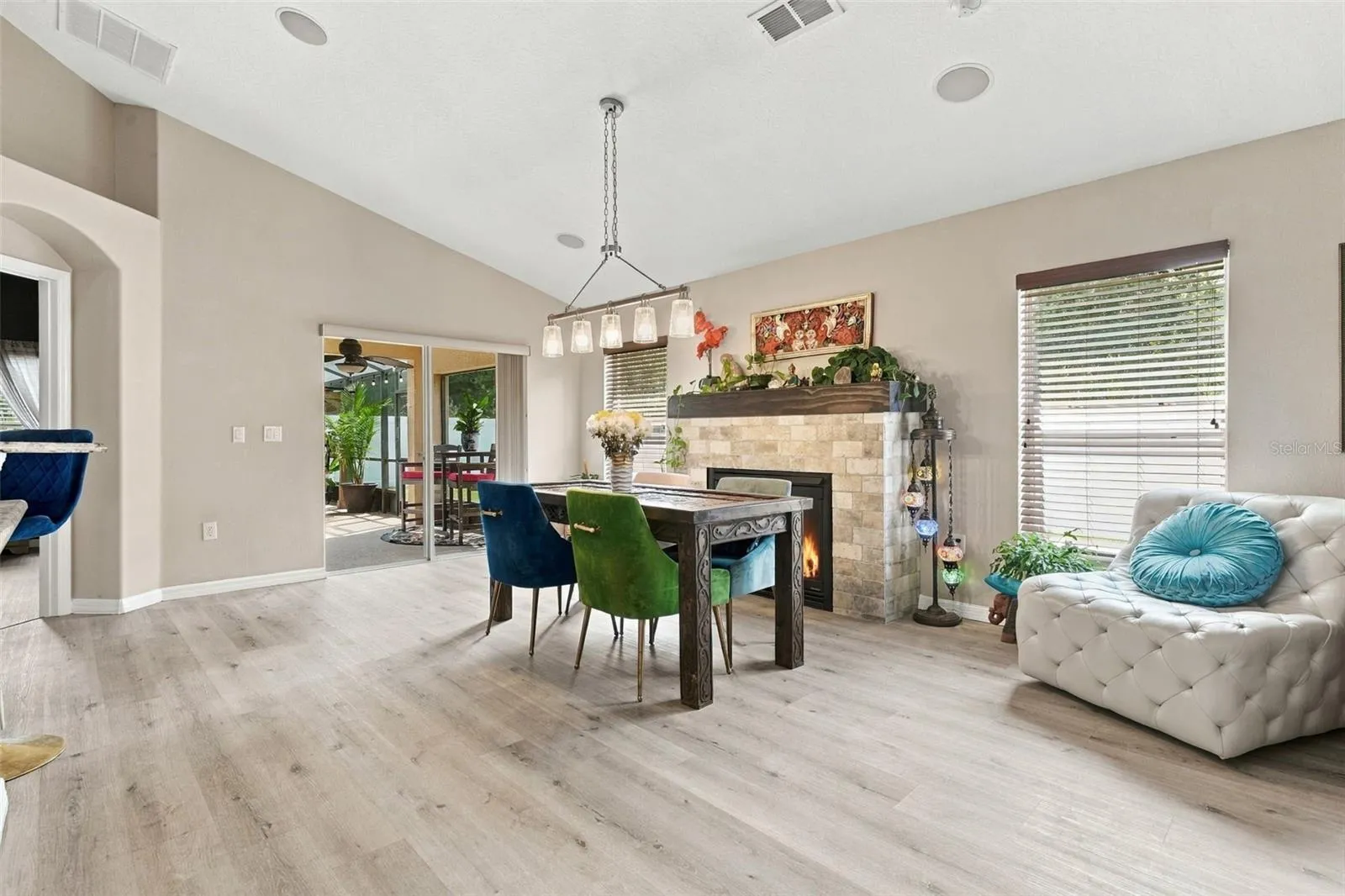 Dining area towards fireplace and screened rear lanai.