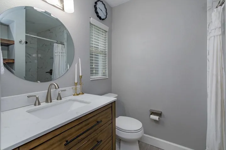 Primary ensuite with updated quartz-topped vanity and shower