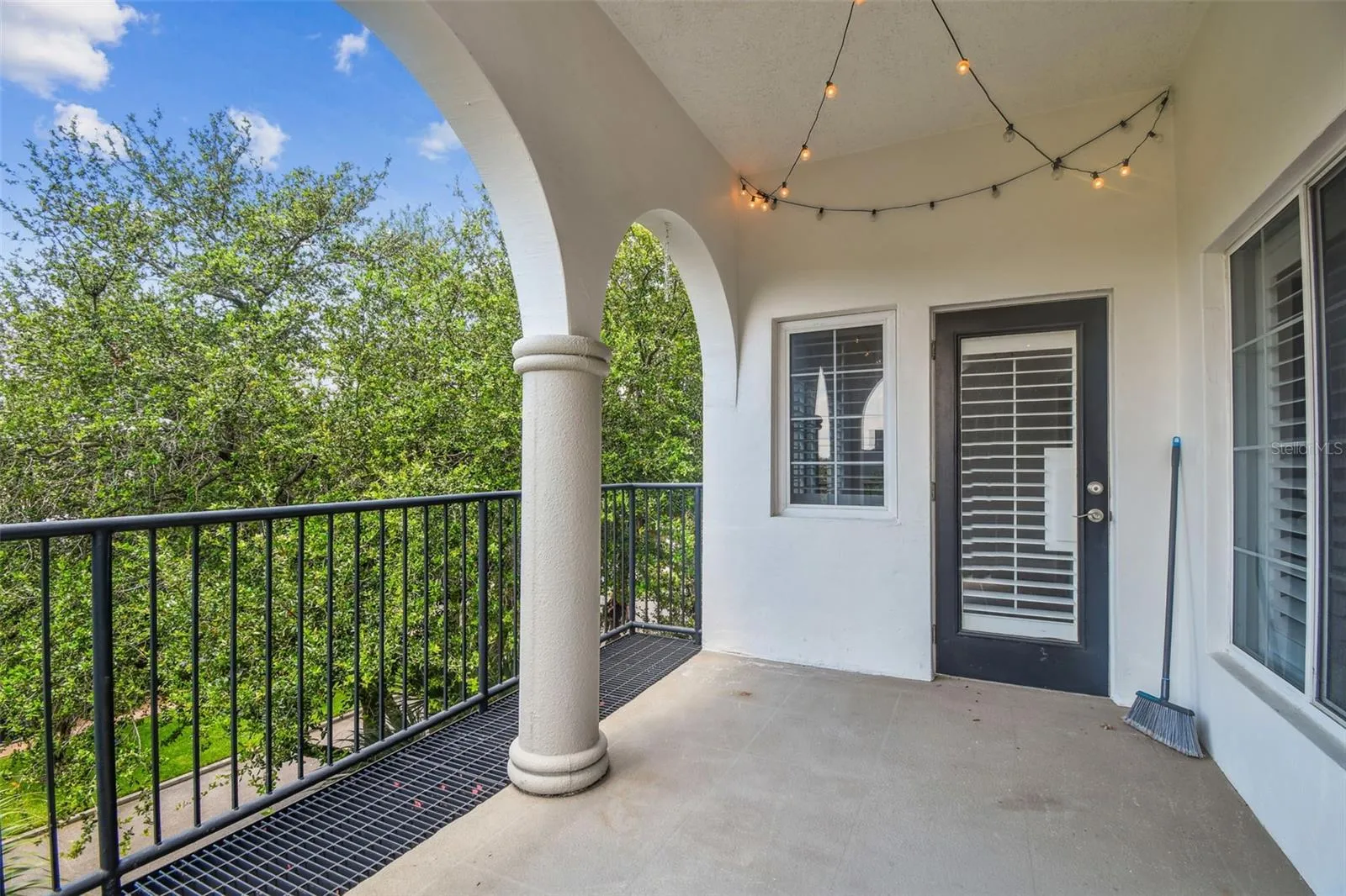 Enclosed outdoor patio overlooking tree-lined street.