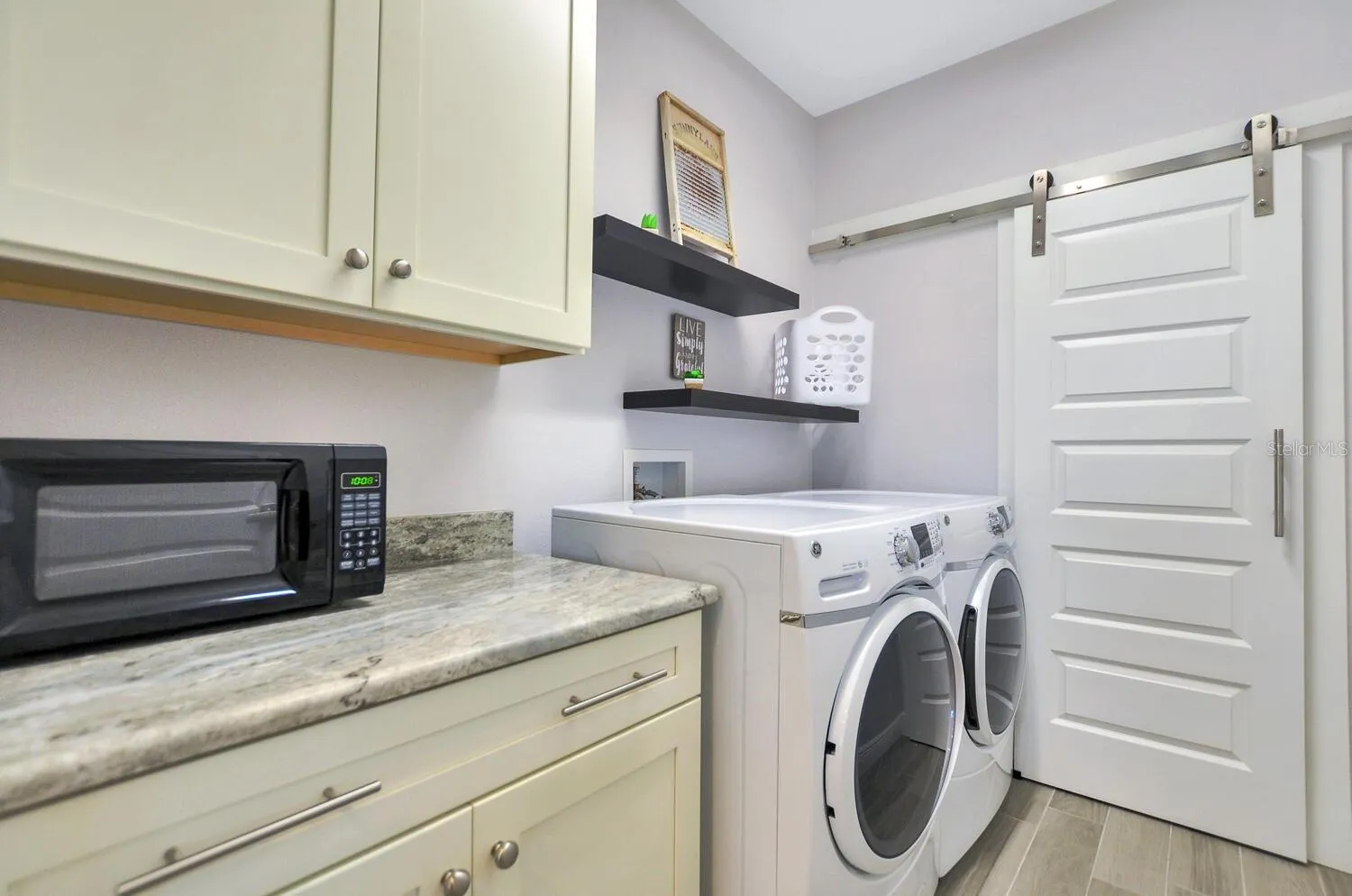 laundry room with barn door to storage room