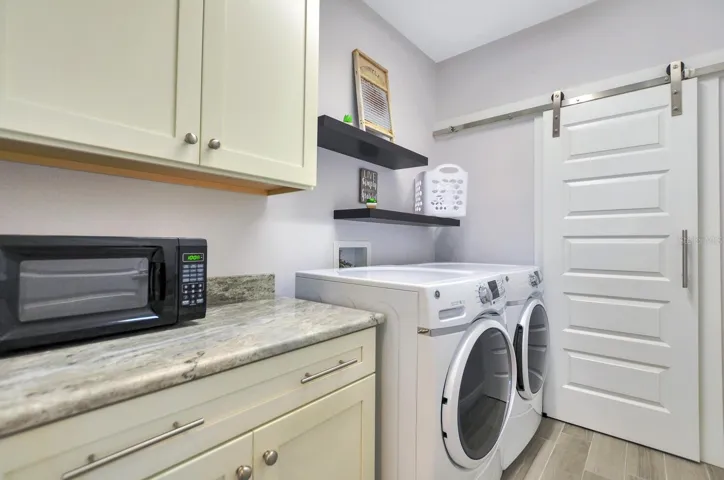 laundry room with barn door to storage room