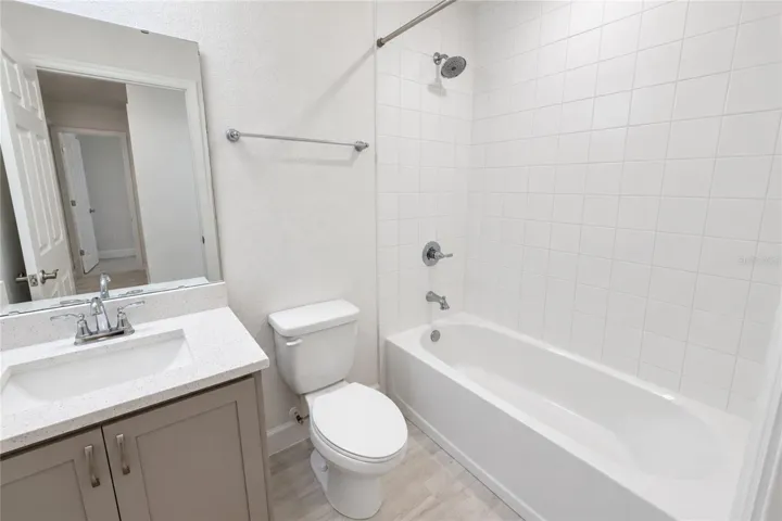 FIRST BATHROOM VIEW WITH QUARTZ COUTERS ON SINK
