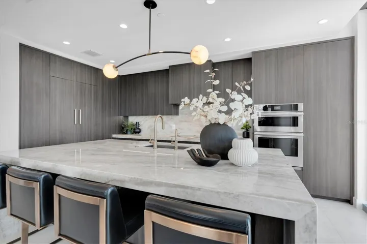 Gourmet kitchen 3" mitered Taj mahal countertops with waterfall on both edges of the island.