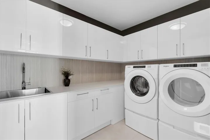 Dedicated laundry room with built-in cabinets.