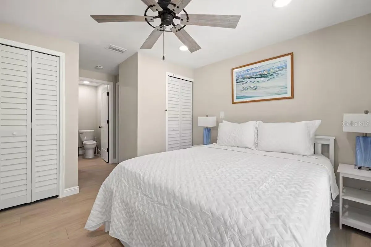 Another view of the primary suite highlights TWO CLOSETS and convenient access to the ensuite bath.