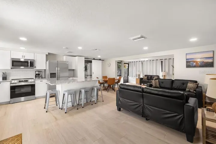 This wide-angle view really shows off the OPEN FLOOR PLAN, connecting the kitchen, dining, and multiple living spaces for easy everyday living and entertaining.