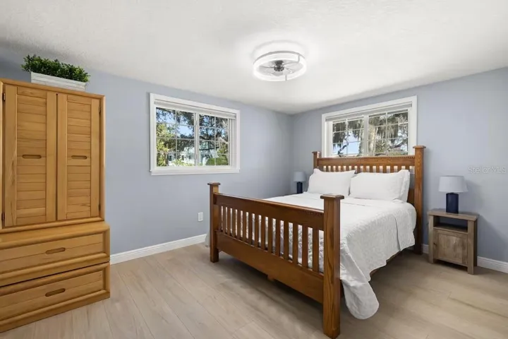 Two windows bring natural light into this nicely sized guest bedroom, with plenty of room for additional furniture.