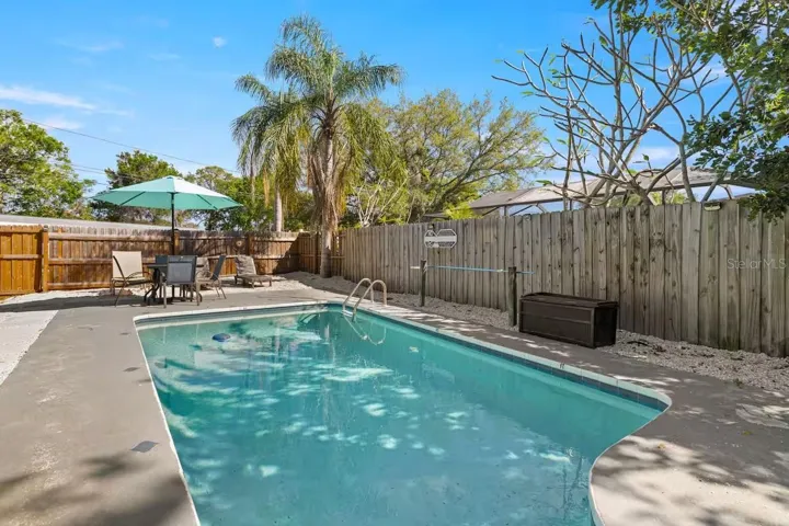 Sparkling in-ground pool surrounded by a spacious deck and privacy fencing—your own backyard escape for sunny Florida days.