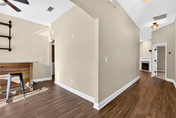 View from front door. Hallway straight ahead and dining room/bar to the left.