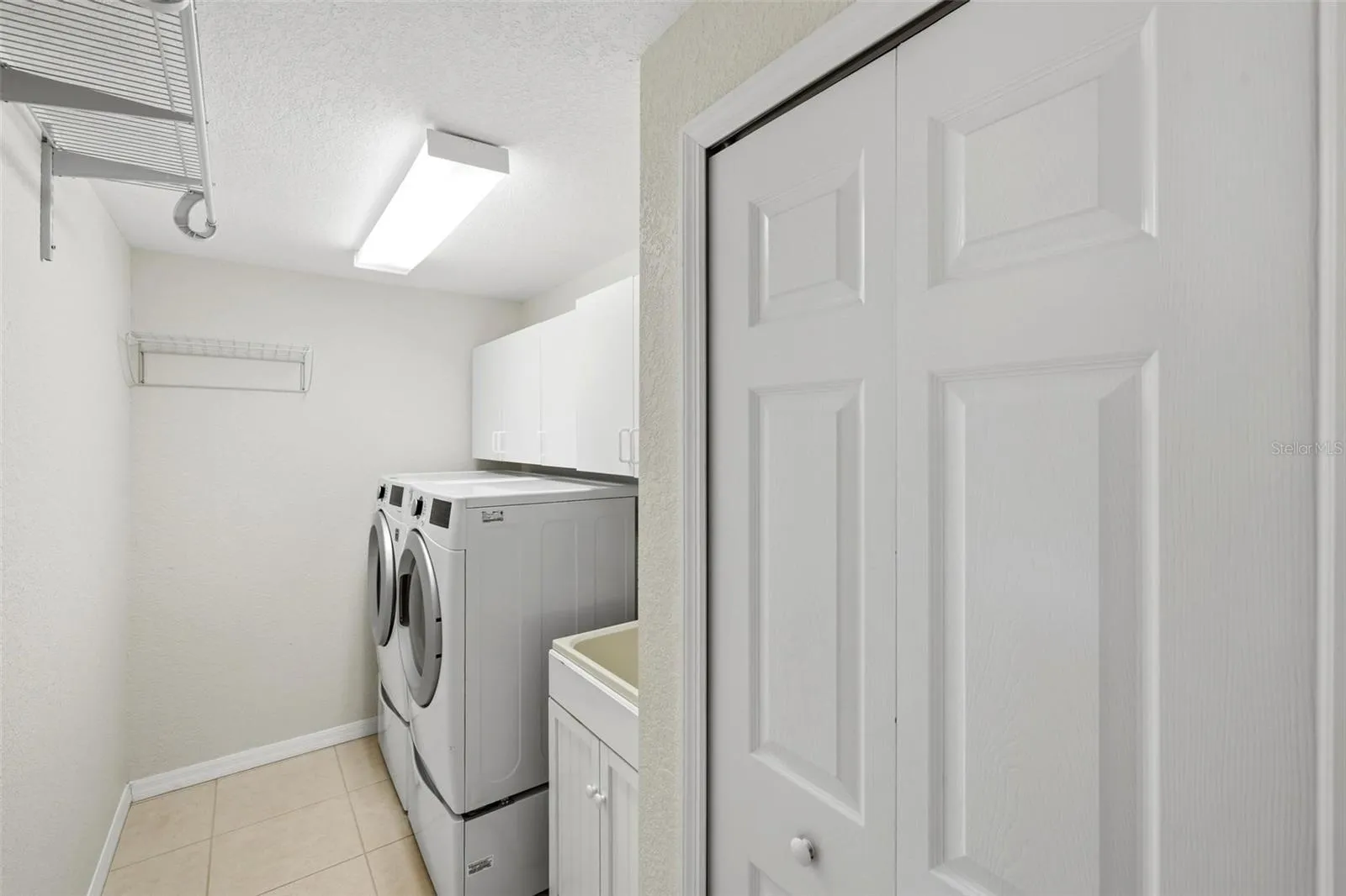 Inside Utility room... deep sink, cabinets and storage closet..
