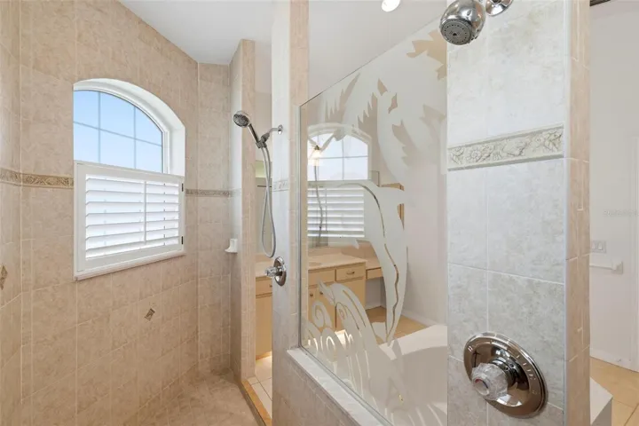 Primary Bathroom Roman style walk-in shower with dual shower heads and dual controls... Beautifully Tiled...