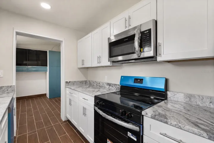 Upgraded kitchen with tons of counter space with access to laundry room