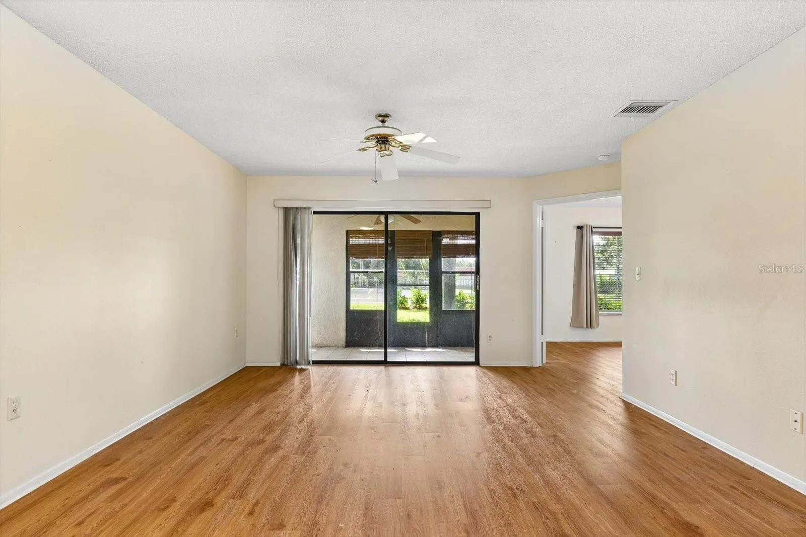 Living Room with Ceiling Fan and Sliders to Back Porch