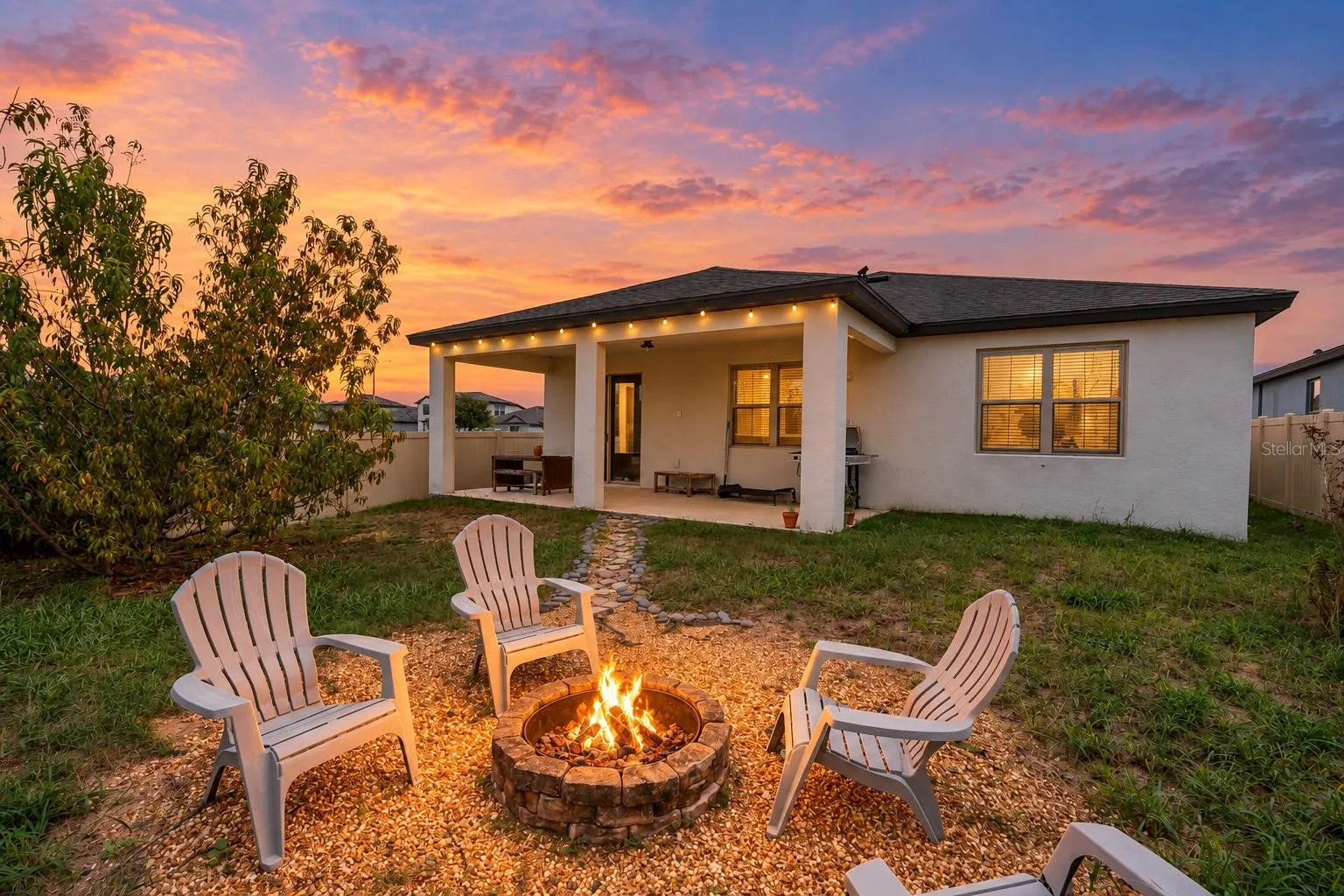 twilight of rear patio, yard and fireplace