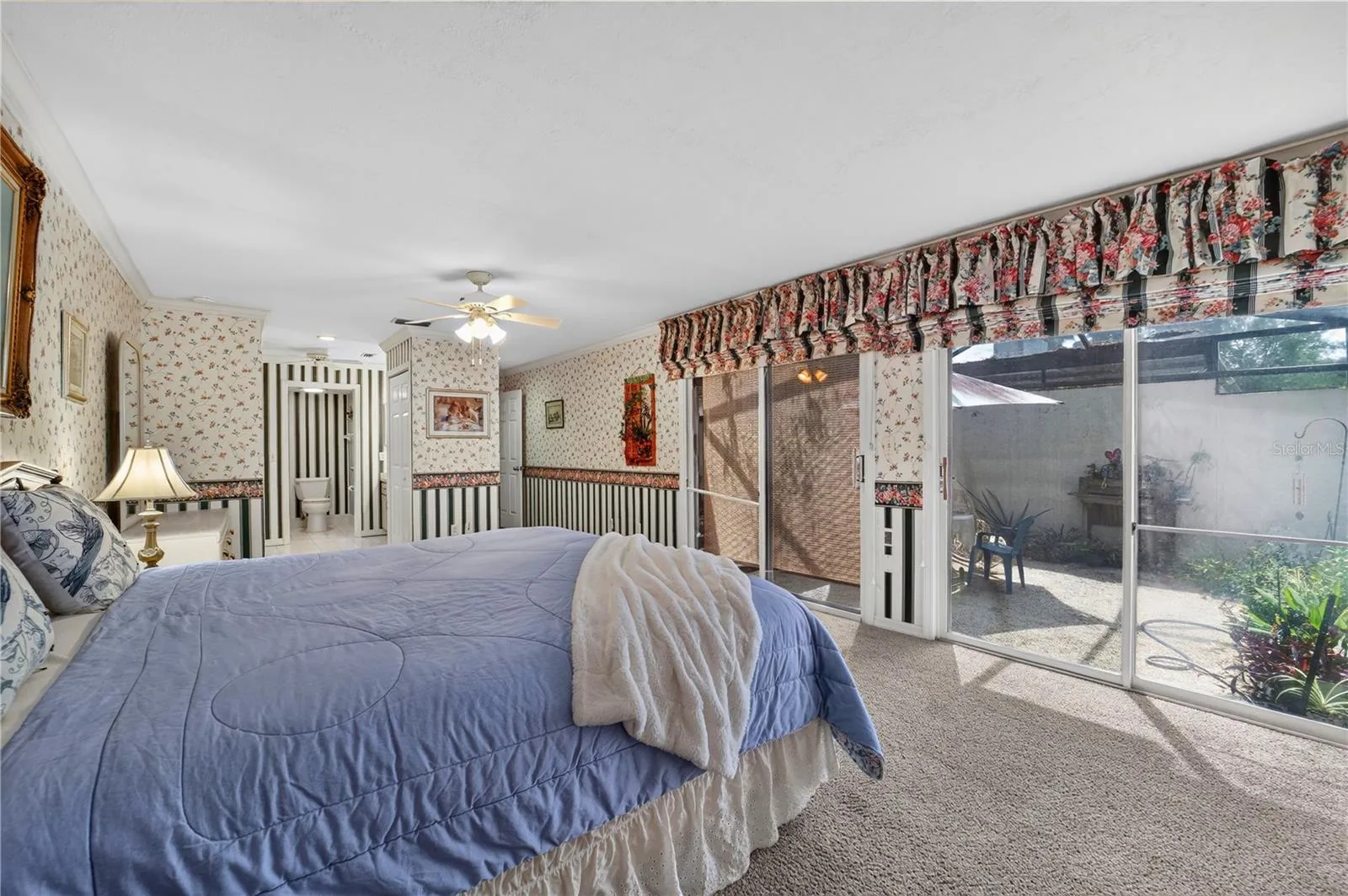 The primary bedroom has access to the rear patio through the glass sliding doors.