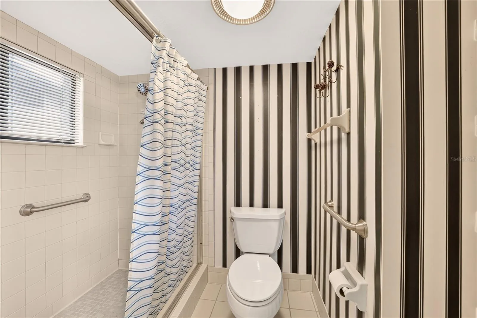 The shower and toilet closet have grab bars for safety