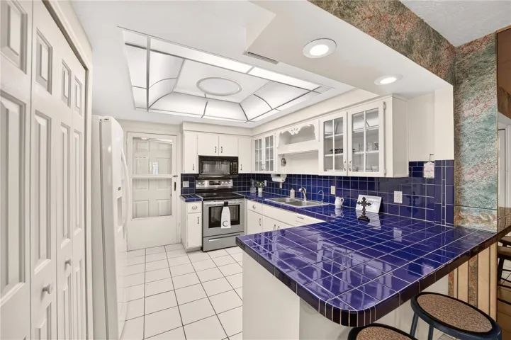 The kitchen is spacious and has lovely cobalt blue tiled countertops.