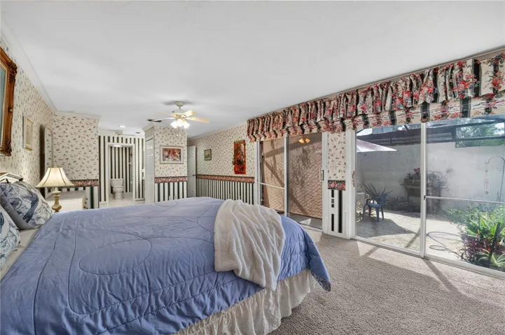 The primary bedroom has access to the rear patio through the glass sliding doors.