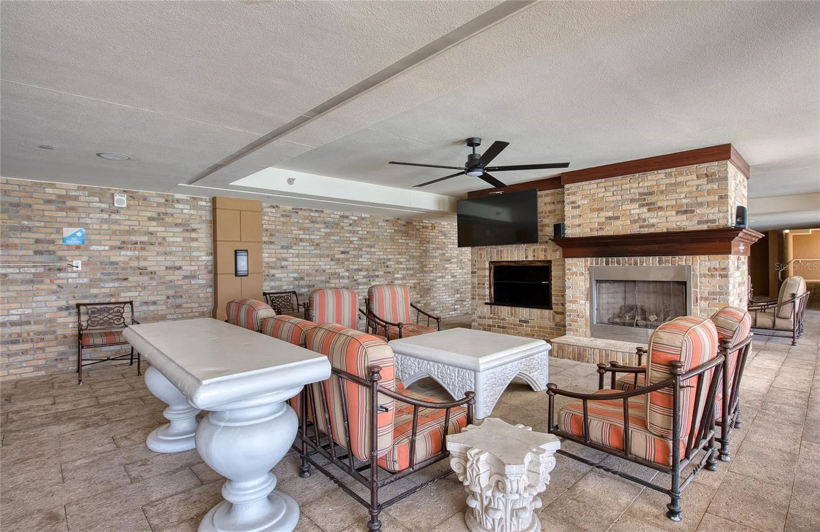 and opens to a covered area with tables, chairs, TV