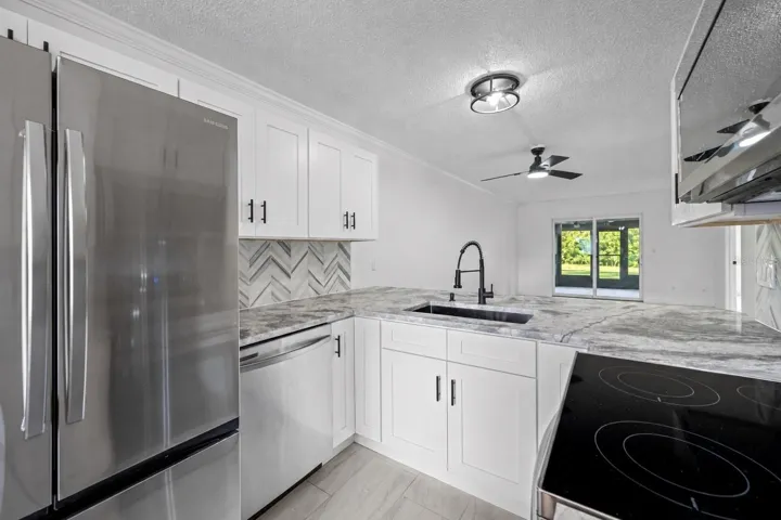 Updated kitchen with Quartzite countertops, soft-close cabinetry, and stainless steel appliances.