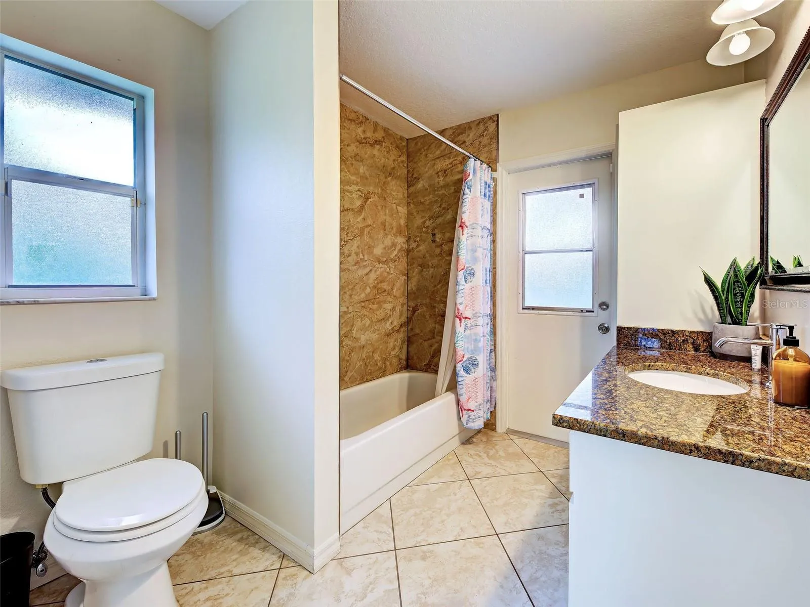 The guest bathroom has a tub/shower combination and a door to the lanai.