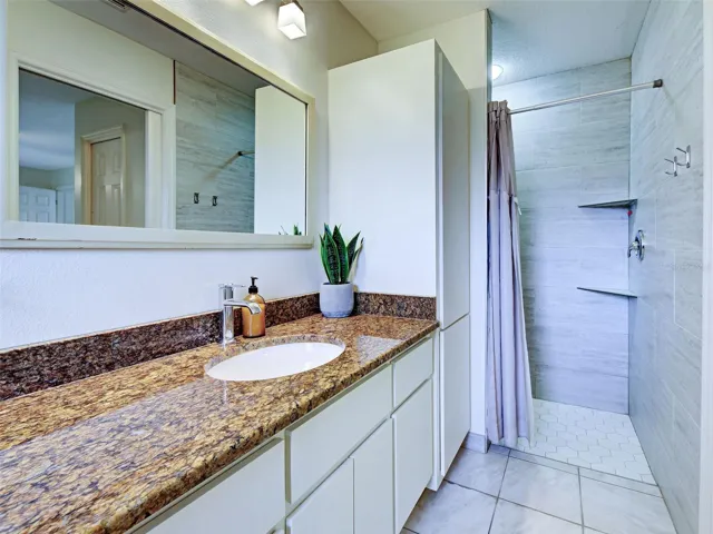 The primary bathroom has a linen closet and walk in shower.  Walk in shower has floor to ceiling tiles.