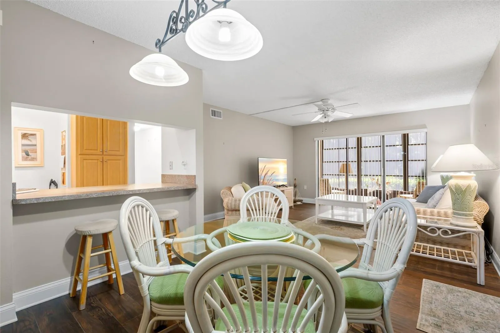 A decorative two-light fixture defines the dining area, while the wide kitchen pass-through adds extra counter space and keeps the kitchen connected to the living space.