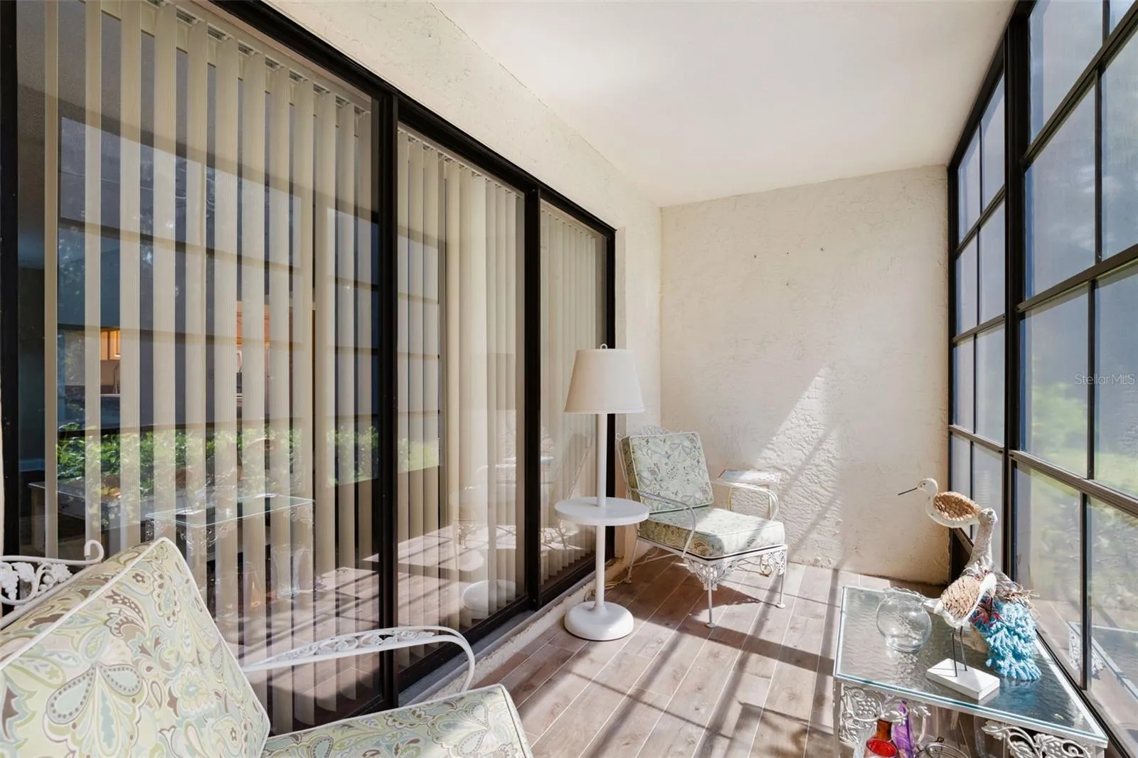 Sliding glass doors connect the living room directly to the screened lanai, making this a natural extension of the indoor space for reading, morning coffee, or simply enjoying the preserve-side setting.