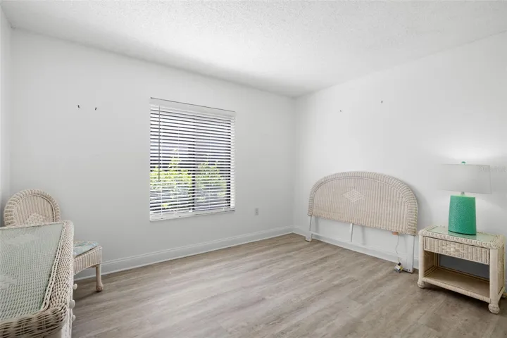 The second bedroom is bright and versatile, with light-toned flooring, a large window, and enough space to serve comfortably as a guest room, home office, or both.