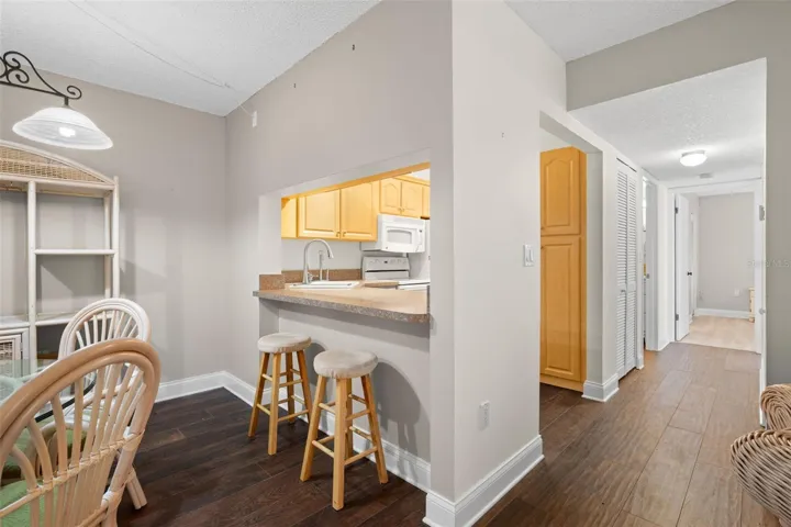 From the dining area, the breakfast bar provides casual seating while the adjoining hallway leads to both bedrooms, baths, and the in-unit laundry.