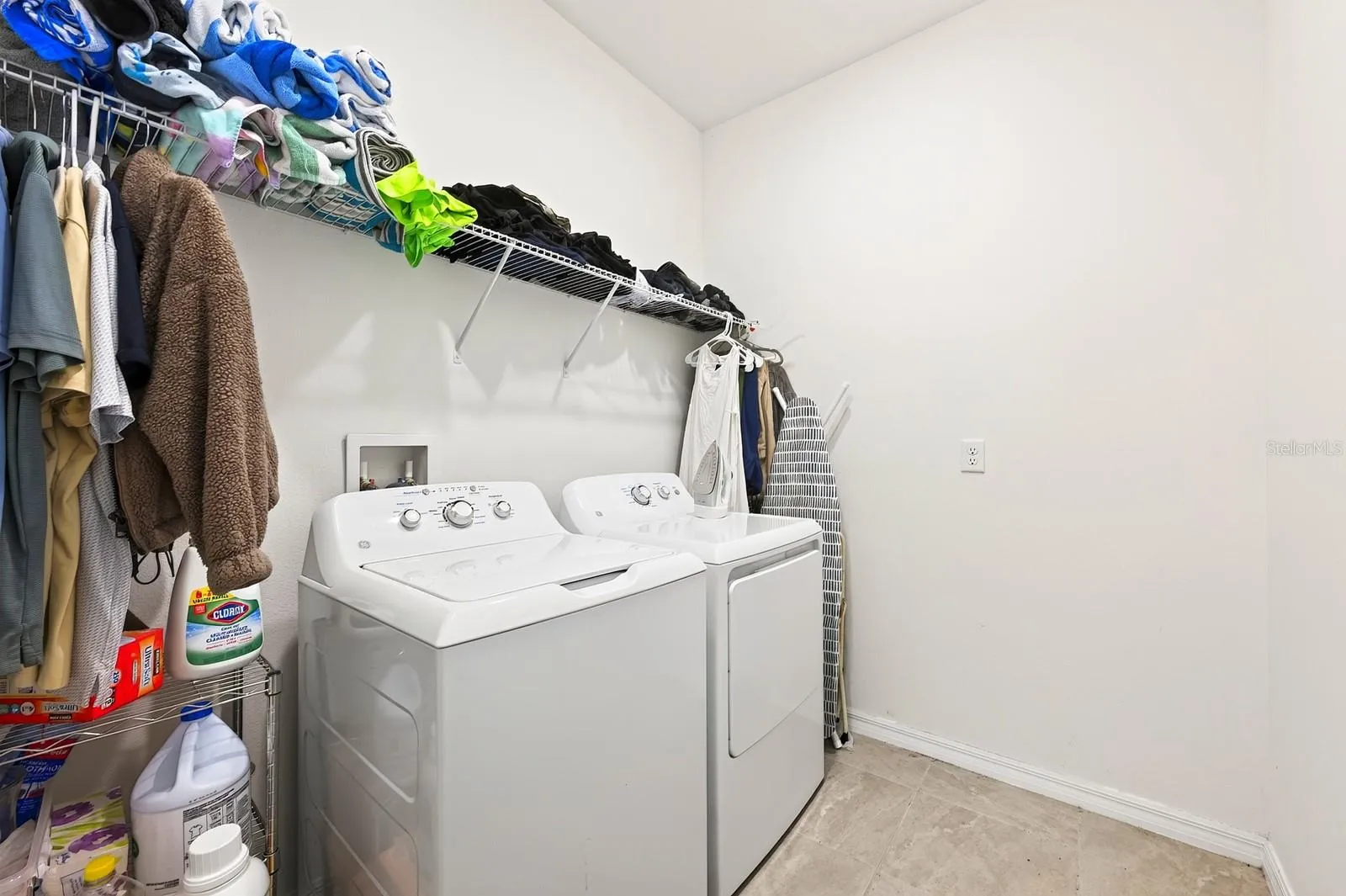 A convenient Laundry Room has shelving to help keep supplies handy.