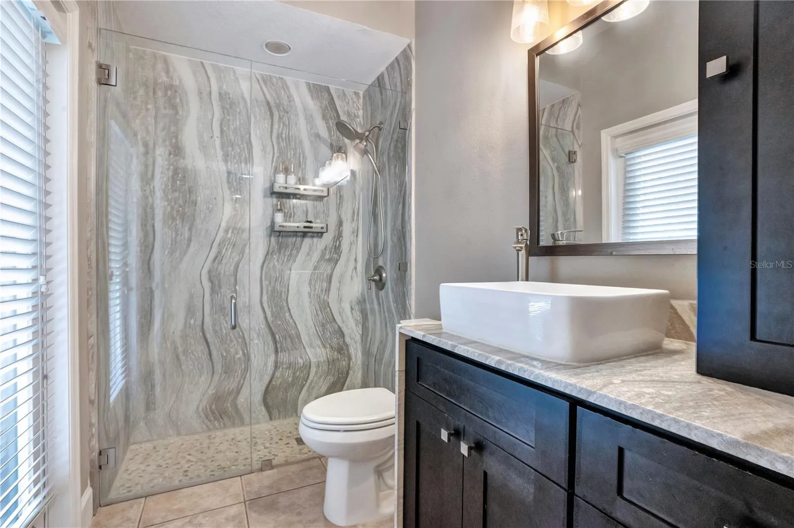 Updated bath with Cambria shower walls and vessel sink.
