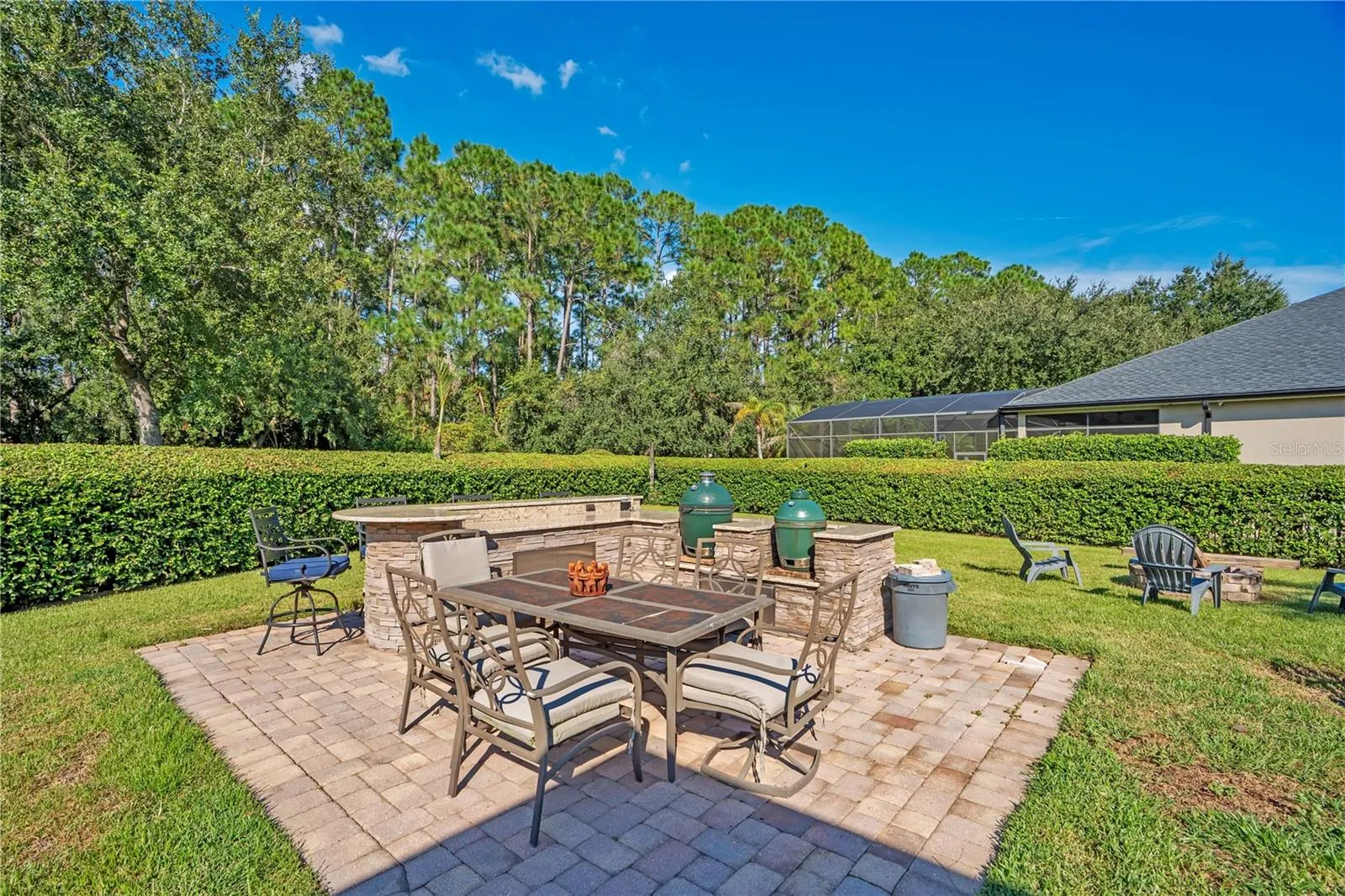 Outdoor kitchen with stone bar and dining patio.