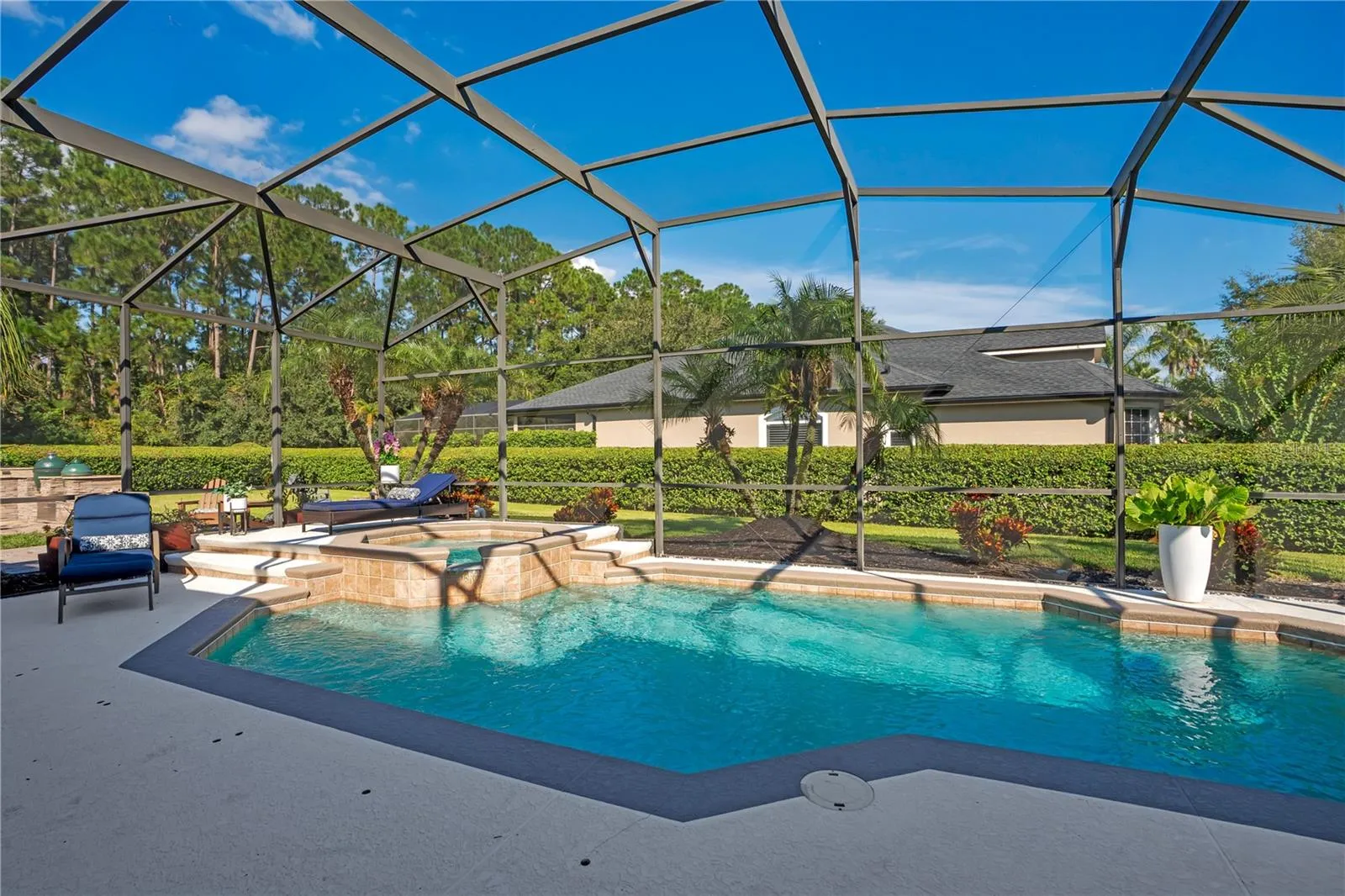 Screened pool and spa with privacy hedge.
