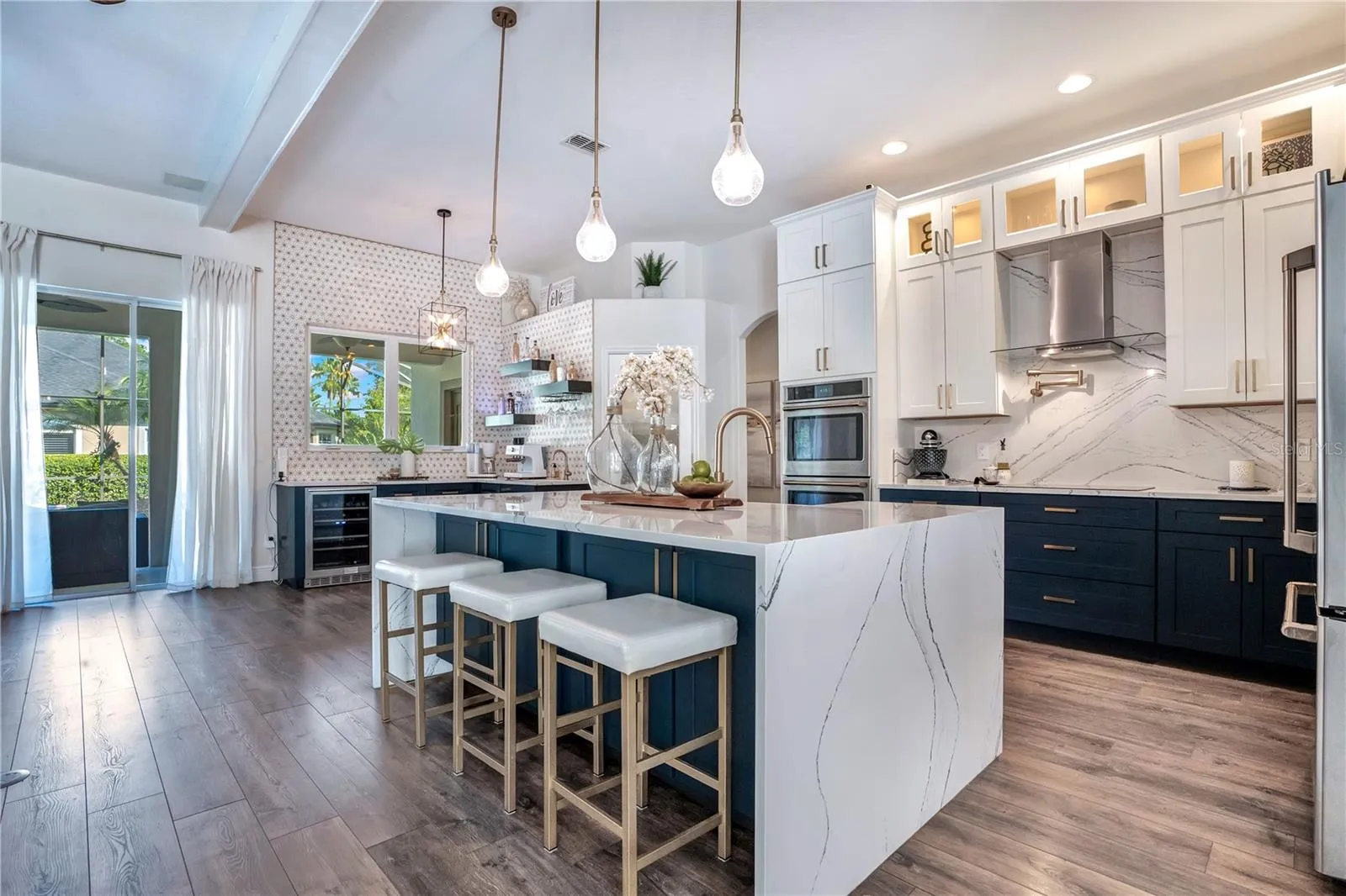 Oversized Cambria waterfall island and glass-front pantry.
