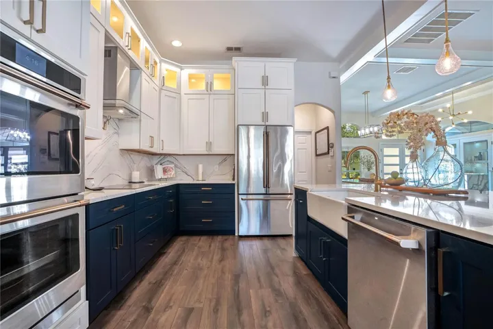 Double ovens, French-door fridge and lit glass uppers.