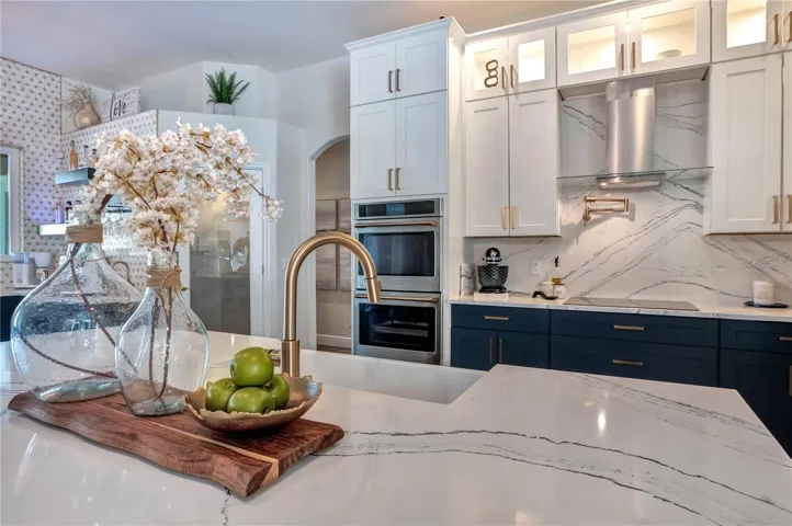 Pot filler, Cambria slab backsplash and gold fixtures.