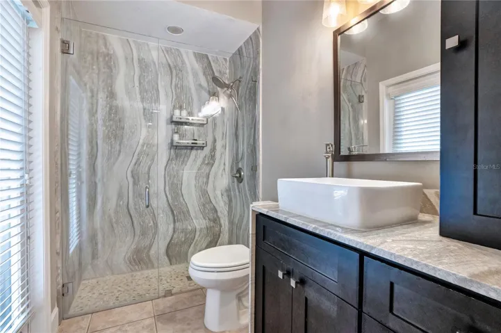 Updated bath with Cambria shower walls and vessel sink.
