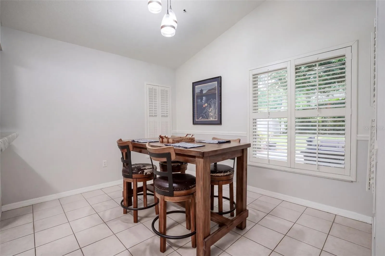 The breakfast nook is surrounded by windows with plantation shutters.