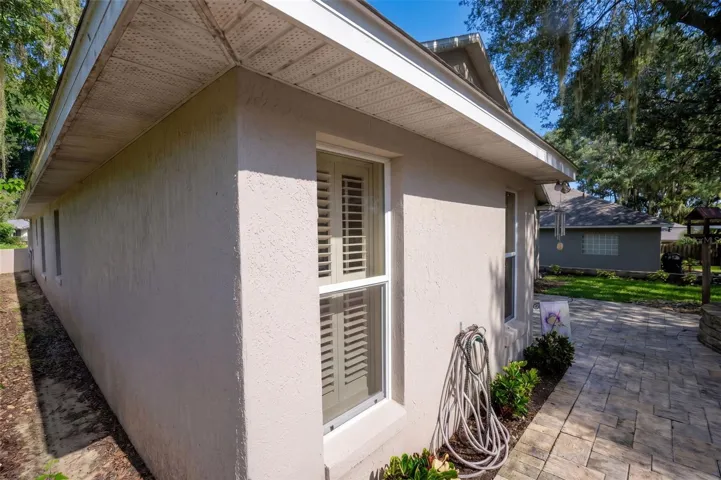 A brick-paver walkway connects the front and rear outdoor spaces.