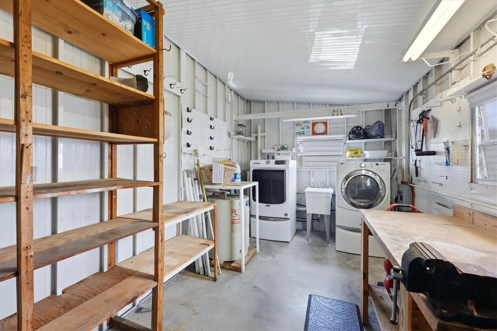 Enclosed Laundry room with workbench and storage