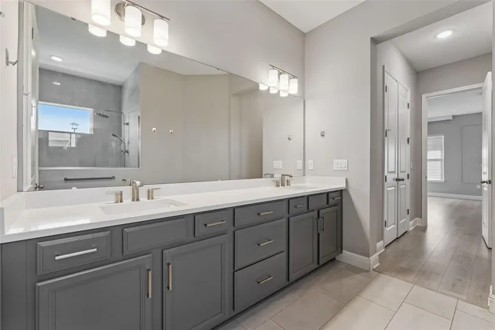 Primary bathroom featuring generous vanity space and modern finishes.