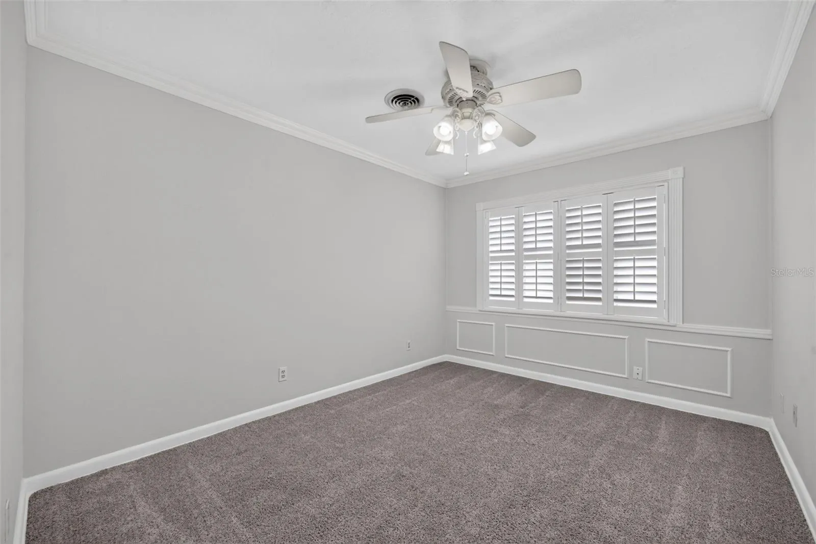 Alternate Bedroom — Ample-sized alternate bedroom with neutral carpeting, crown molding and custom interior shutters.