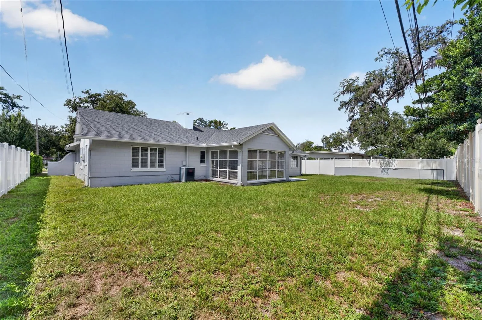 Rear Exterior — Generous fenced backyard with open lawn and plenty of room for outdoor enjoyment.