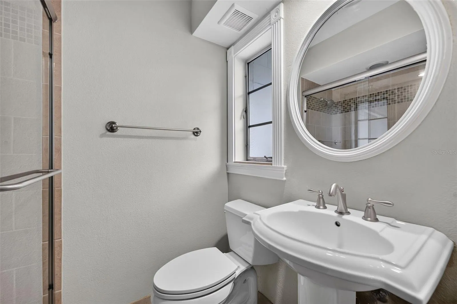 Primary Bath — En suite primary bathroom with pedestal sink and glass-enclosed shower.