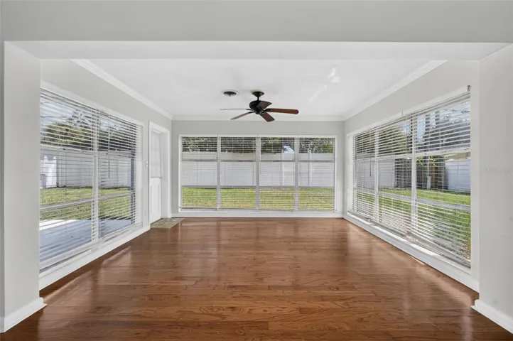 Florida Room — Light-filled Florida room with hardwood floors and expansive windows overlooking the backyard.