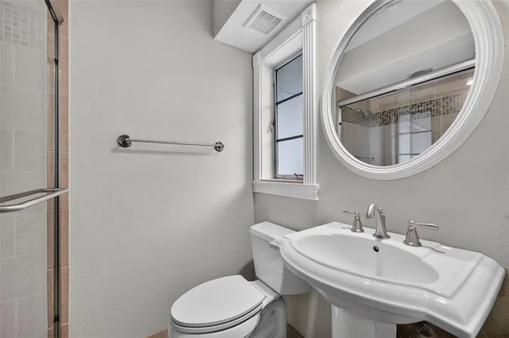 Primary Bath — En suite primary bathroom with pedestal sink and glass-enclosed shower.
