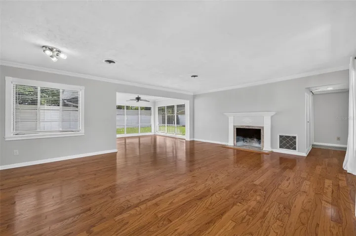 Living &amp; Dining Area — Spacious combined living and dining area with hardwood floors, crown molding, fireplace, detailed millwork and abundant natural light from large-format windows.