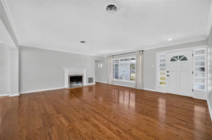 Living Area — Another view of the main living space highlighting the hardwood floors, fireplace, crown molding and natural light.