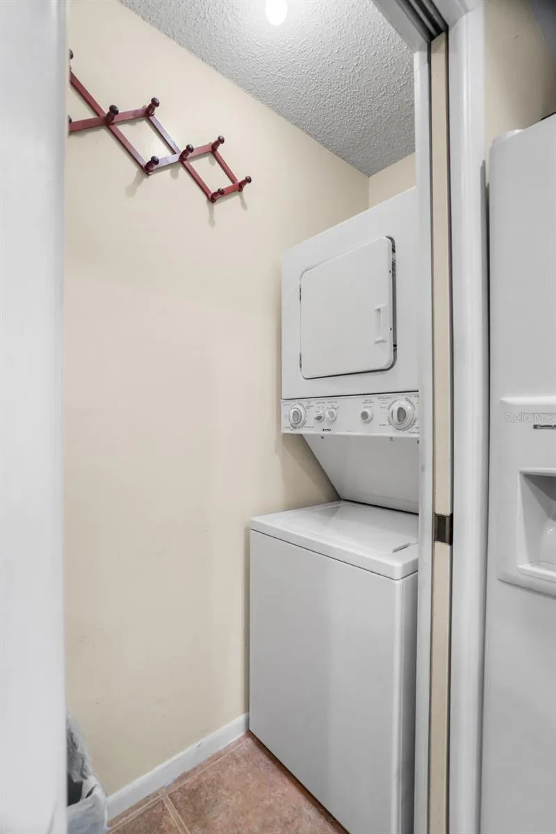 A dedicated laundry closet keeps the washer and dryer tucked neatly beside the kitchen, with a stacked setup that saves floor space while keeping everyday chores conveniently inside the unit.